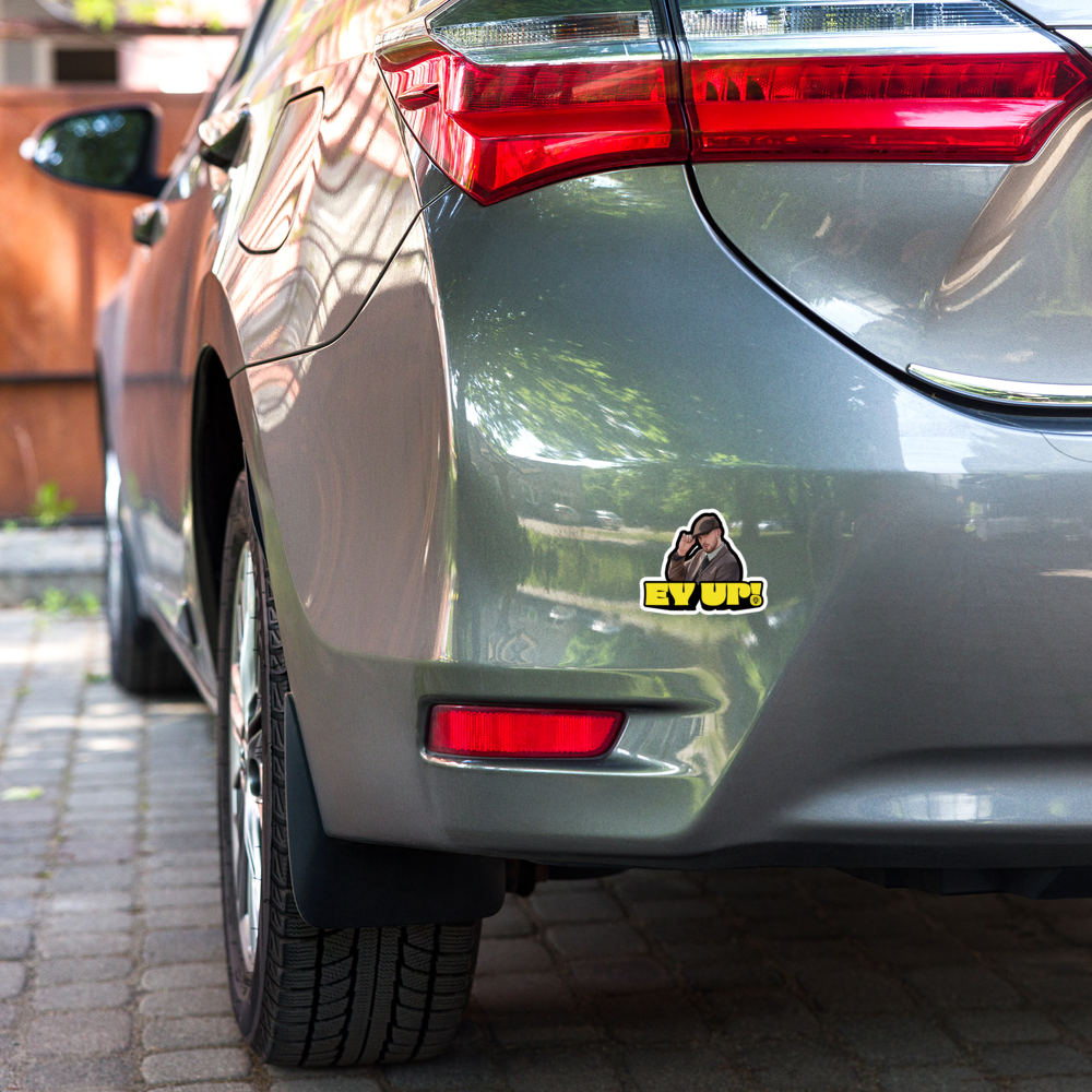 Yellow "EY UP!" sticker on a gray car rear bumper