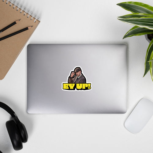 Yellow "EY UP!" sticker with illustrated man raising hand on a laptop